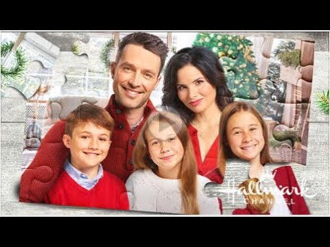 A family of four posing together indoors with a Christmas tree in the background. The image resembles a puzzle, with visible pieces and the Hallmark Channel logo.