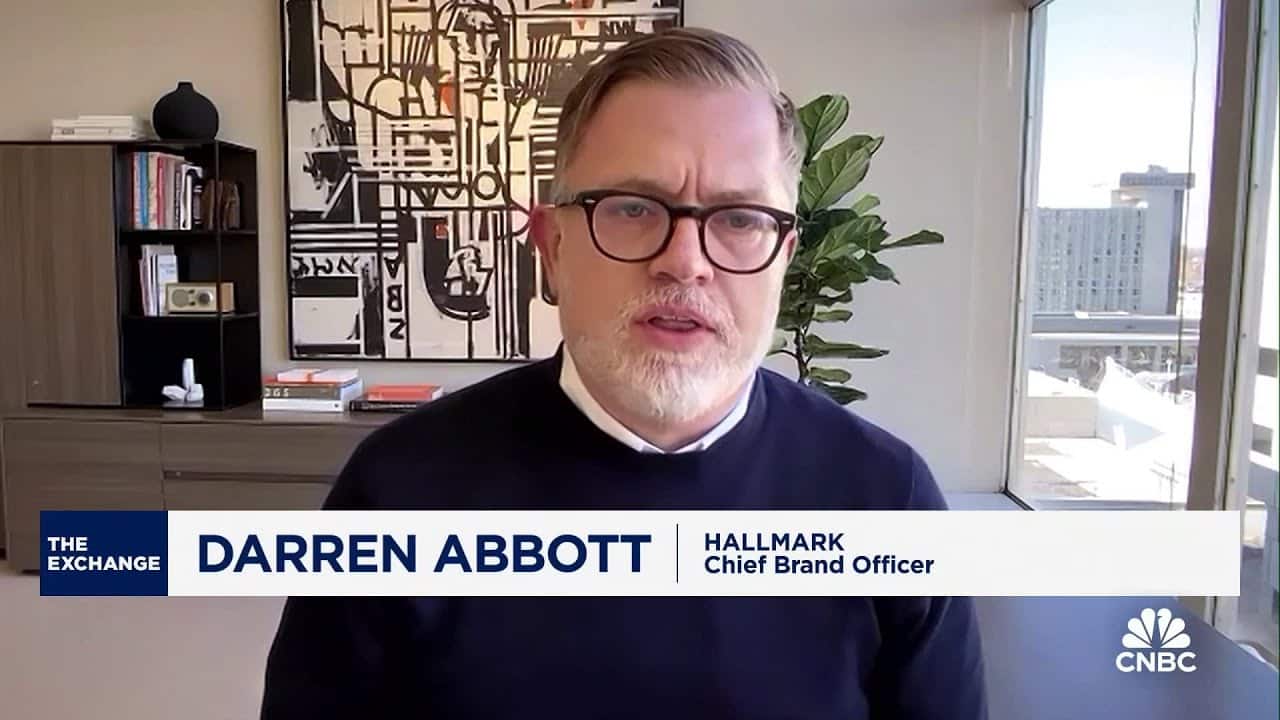 A man wearing glasses and a black sweater speaks during a CNBC interview. Office decor and large windows are visible in the background.