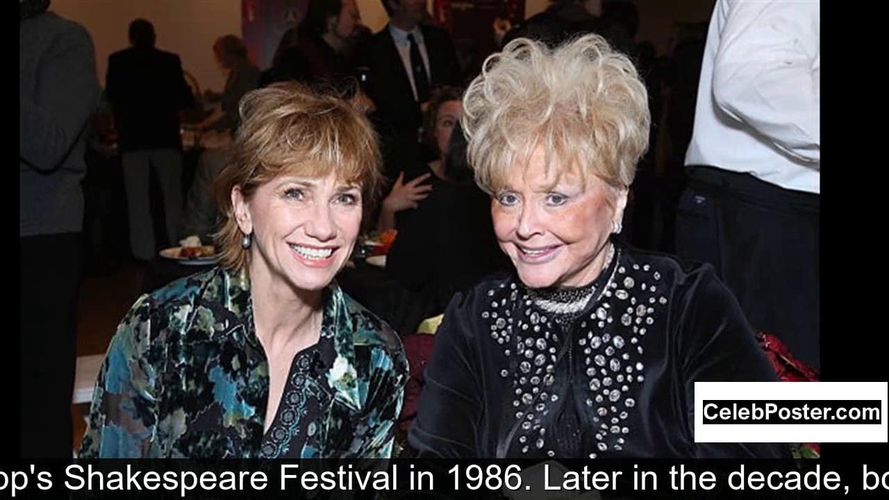 Two smiling women at an indoor event, one wearing a dark floral top and the other in a black outfit with dotted patterns.