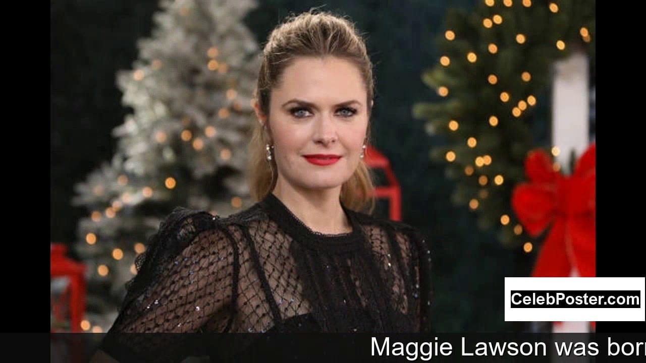 A woman in a black lace top poses in front of a festive background with Christmas trees and lights.