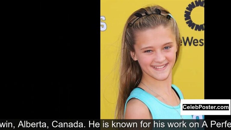 Smiling young girl with long hair wearing a blue top in front of a yellow background.