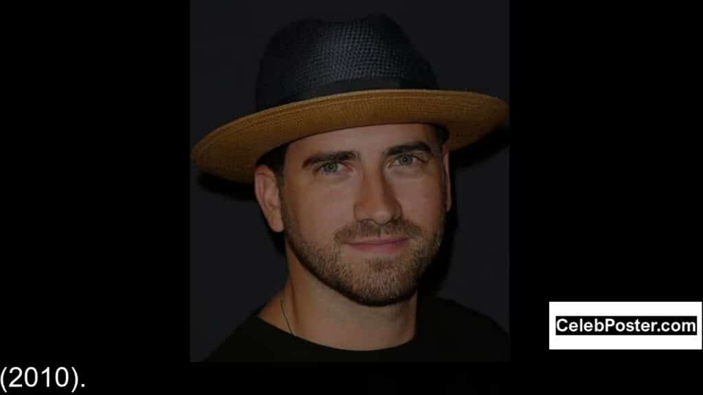 A person wearing a straw hat and a dark shirt against a black background.