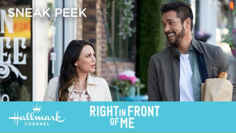 A man and woman walk outside, talking and smiling, with the Hallmark Channel logo and "Right in Front of Me" text at the bottom.