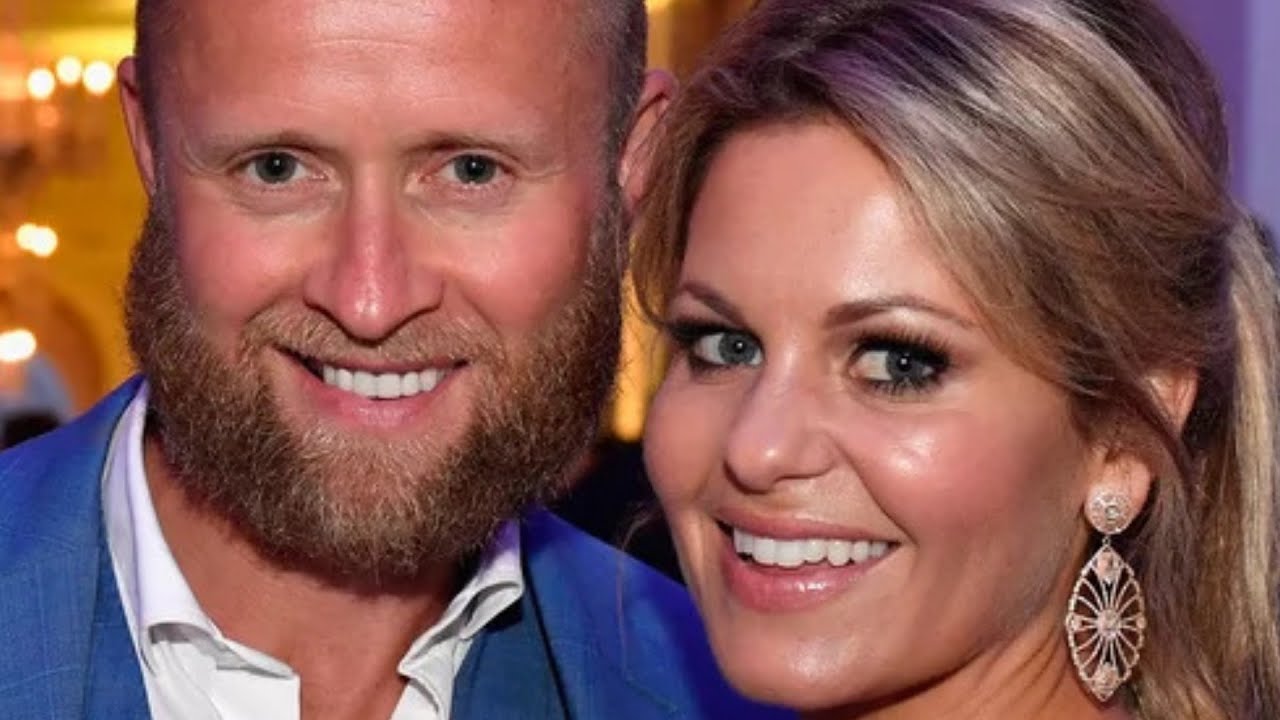 A man with a beard and a woman with earrings smiling at the camera.