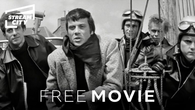 Black and white image showing five people in leather jackets and helmets. Center individual in a coat, all standing near ropes. Text reads "Stream City" and "Free Movie.